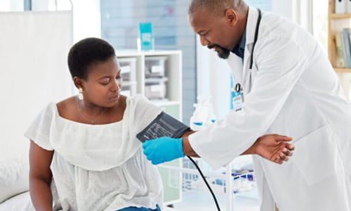 A doctor securing a blood pressure cuff to a patient