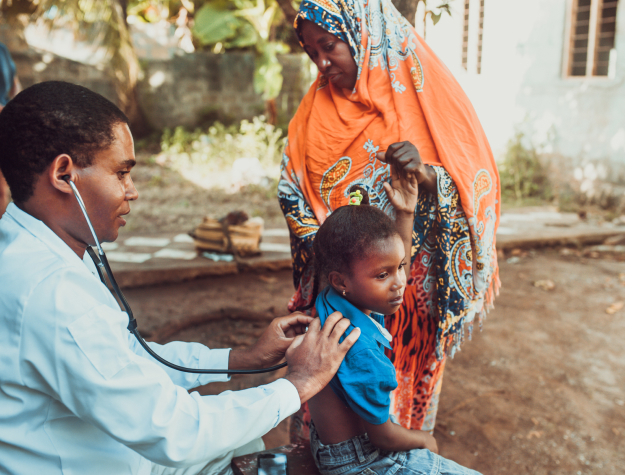 A doctor examining a child outdoors