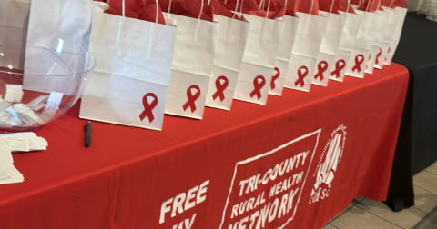 Red tablecloth with white bags on top