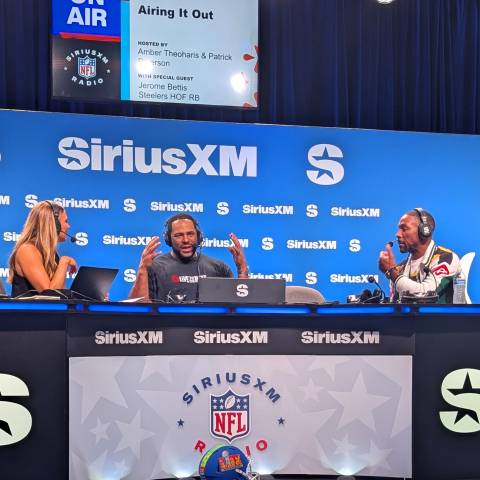 Jerome Bettis sits at a desk interviewed by a man and woman from Sirius Radio